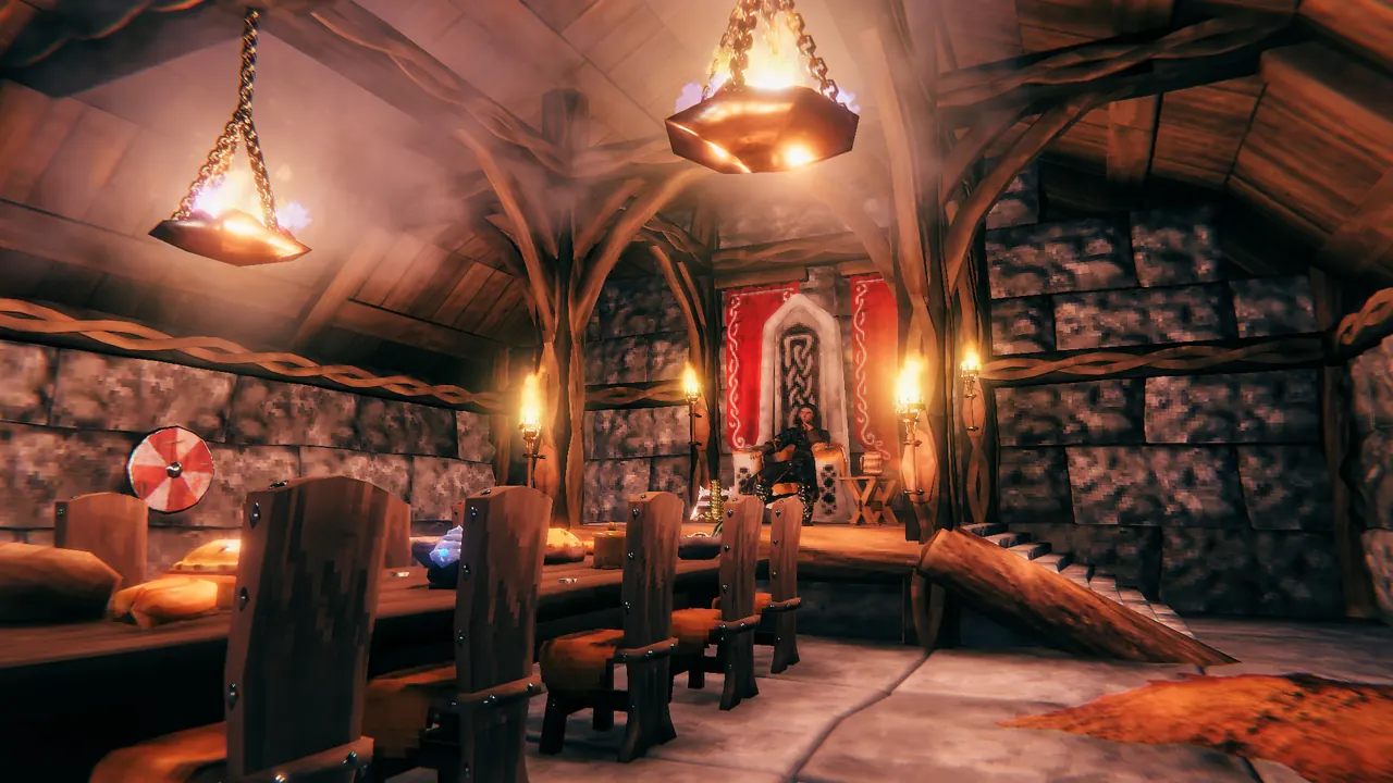 Inside a finished Viking longhouse with a long table, chairs, hanging braziers and a banner